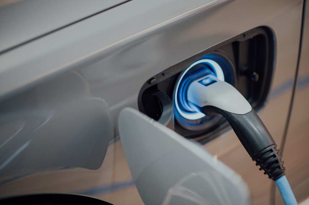 Close-up of an EV charging connector plugged into a vehicle's charge port